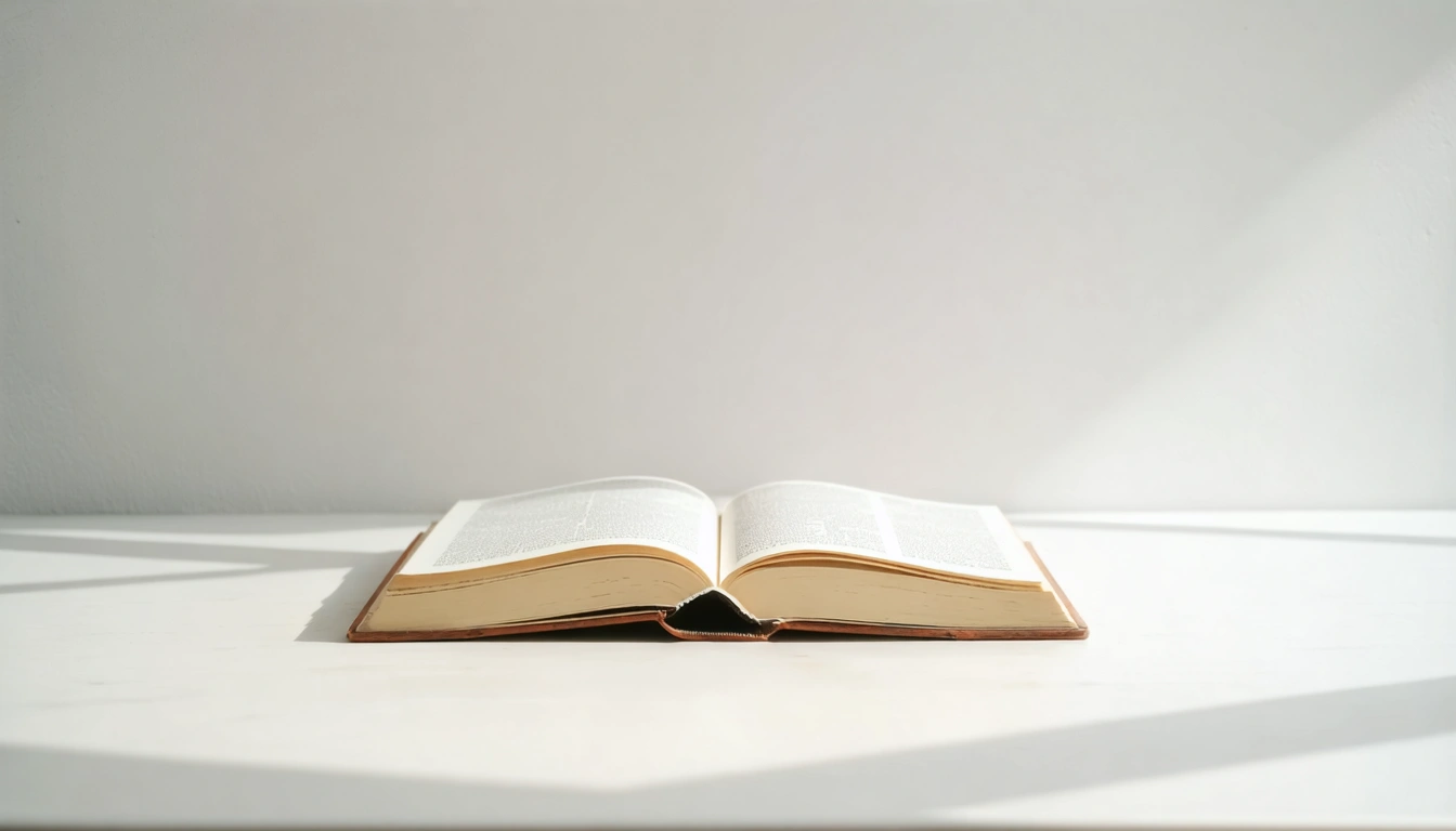 Ein aufgeschlagenes Buch auf einem hellen Untergrund, weicher Schatten, neutrales Studiofoto